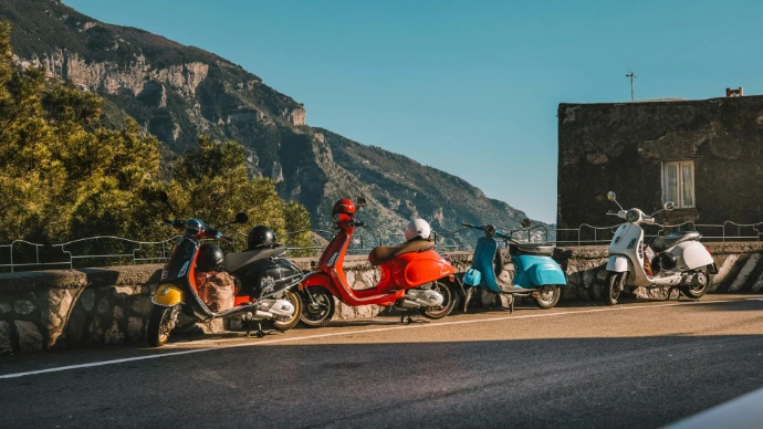 Vespas in Italië die aan de kant vann de weg geparkeerd staan met een mooi uitzicht.