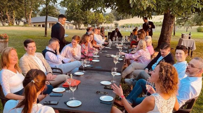 Mensen op business incentive die samen aan een tafel zitten in een mooie tuin-omgeving